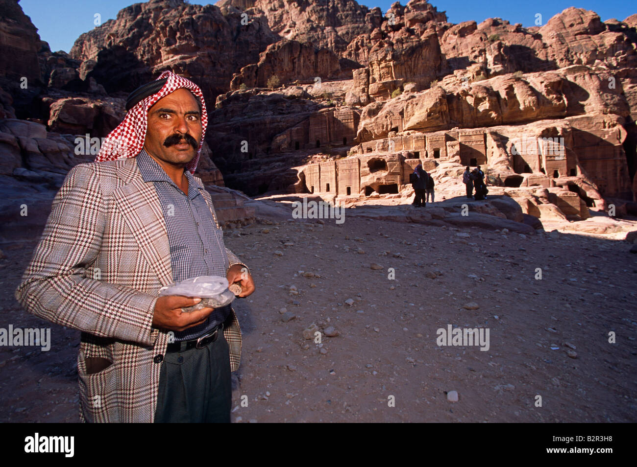 Turista masculino en el Acantilado de roca arenisca edificios tallados, Petra, Jordania, Oriente Medio Foto de stock