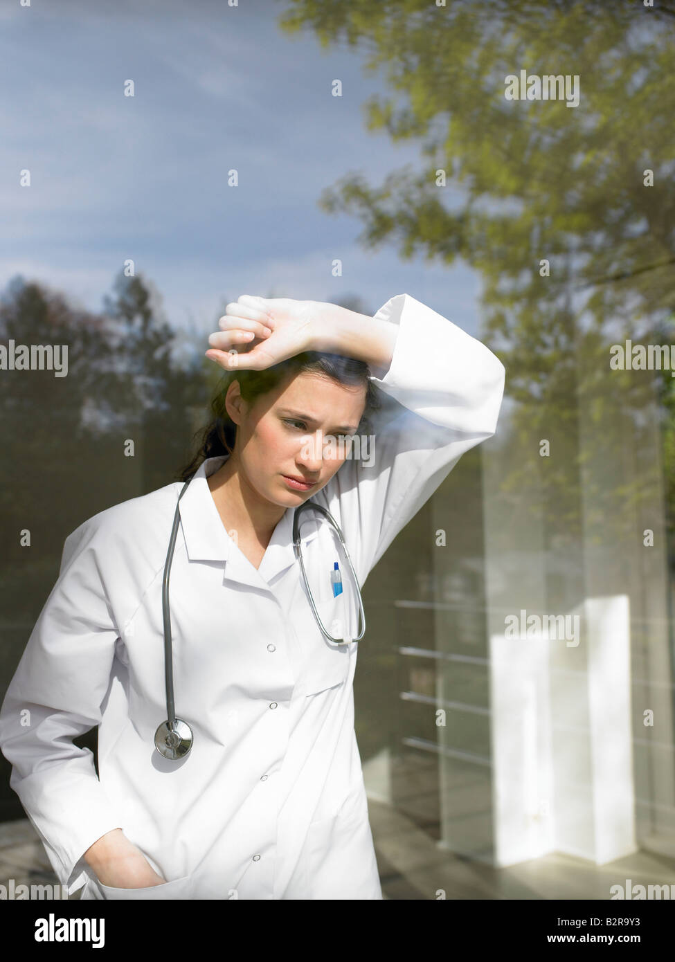 Joven doctora por la ventana Foto de stock