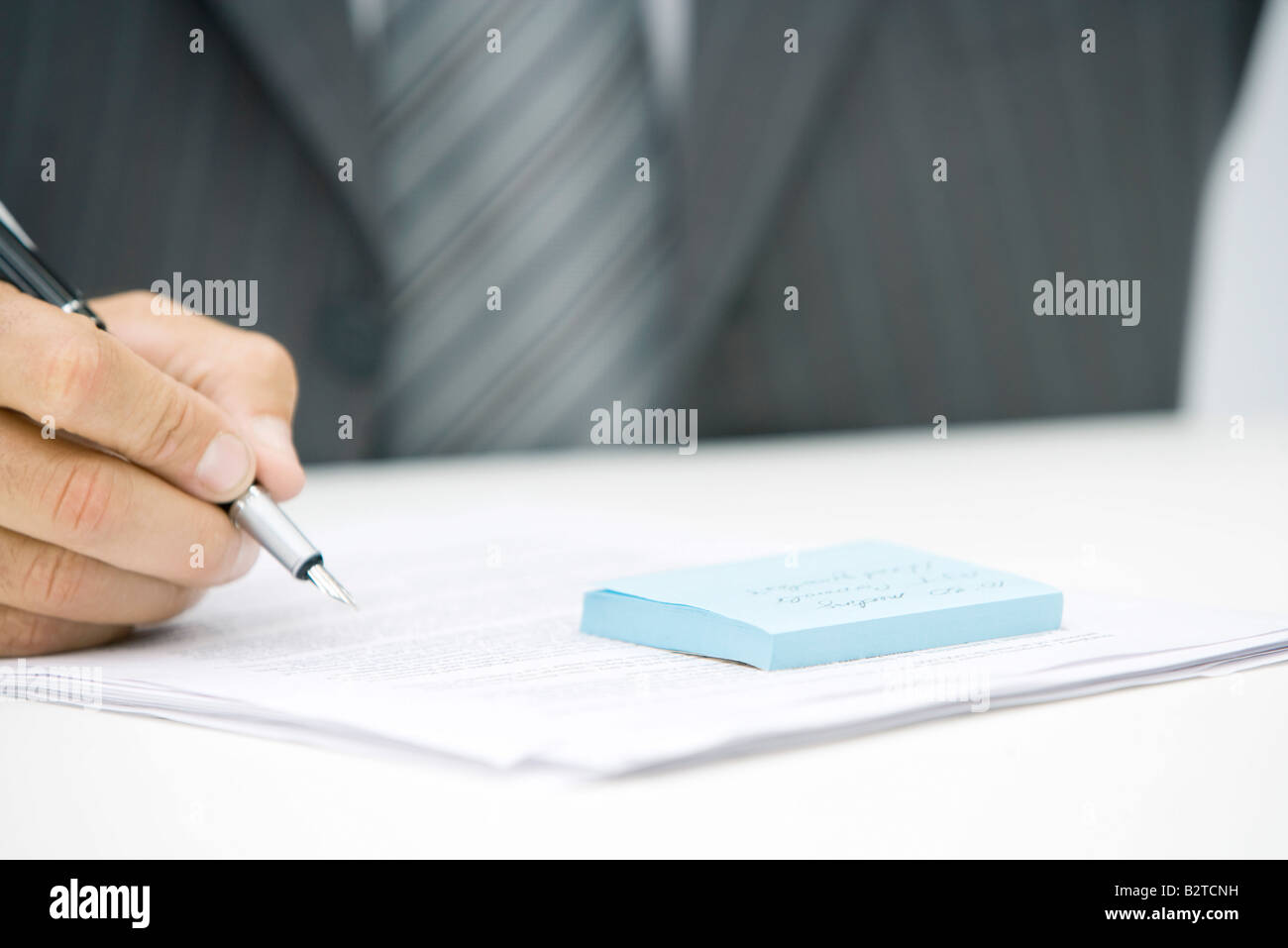 Hombre con nota adhesiva y documento, sosteniendo pen, vista recortada Foto de stock