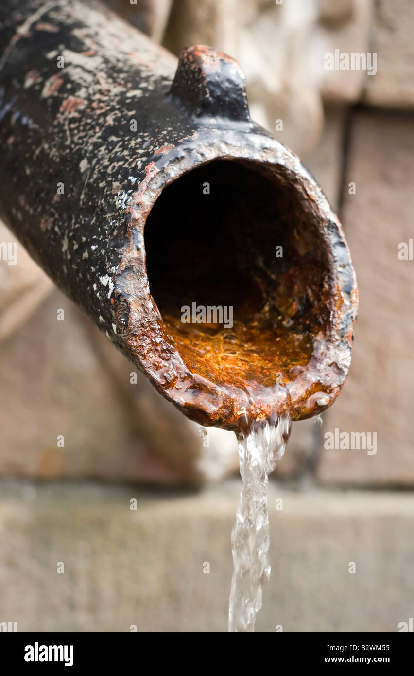 Agua de fuente con tubo de hierro oxidado Foto de stock