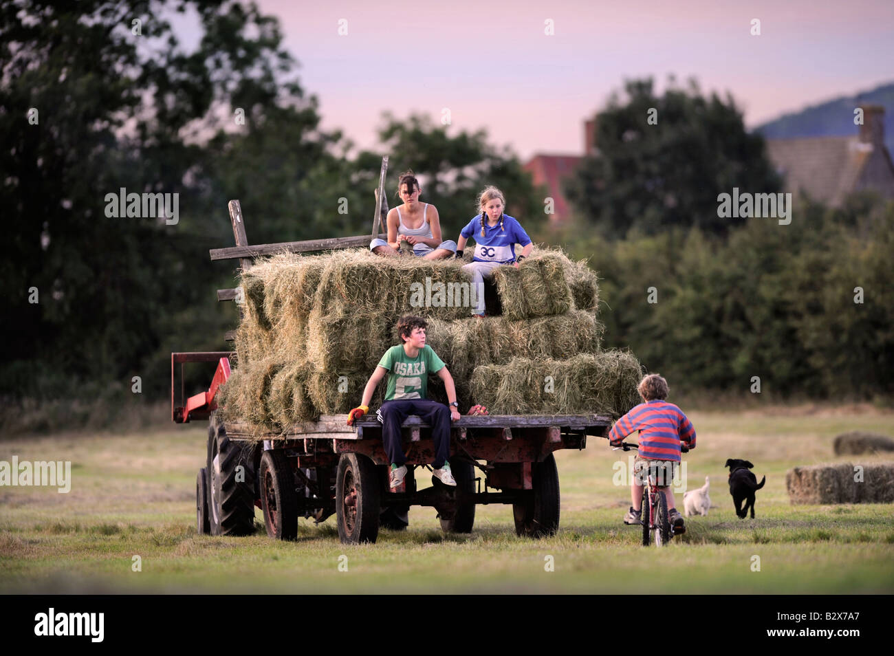 Una familia de agricultores recoger el heno en el estilo tradicional en Gloucestershire, Reino Unido Foto de stock