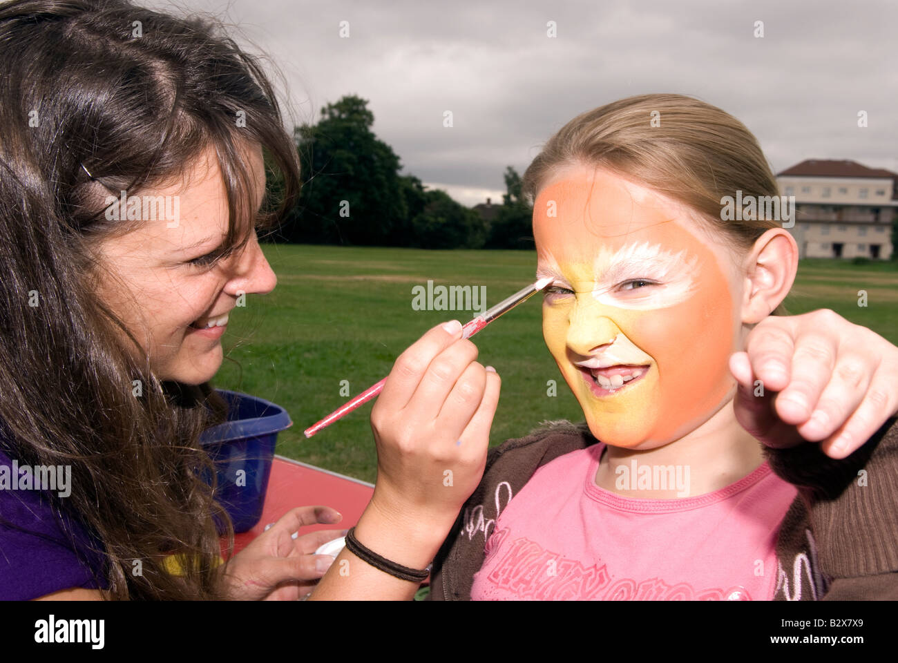 Niña de 4 años con la cara pintada en un día de diversión de la comunidad exterior Hanworth Middlesex UK Foto de stock