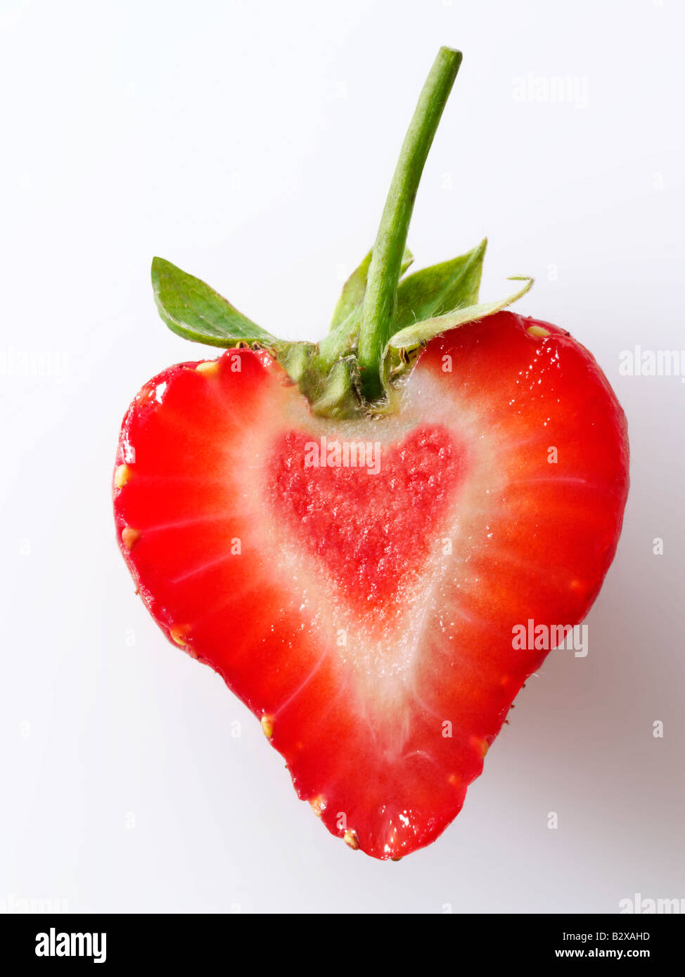 En forma de corazón de Fresas orgánicas , cortes estilizados concepto creativo foto representa un corazón sano, sobre un fondo blanco. Foto de stock