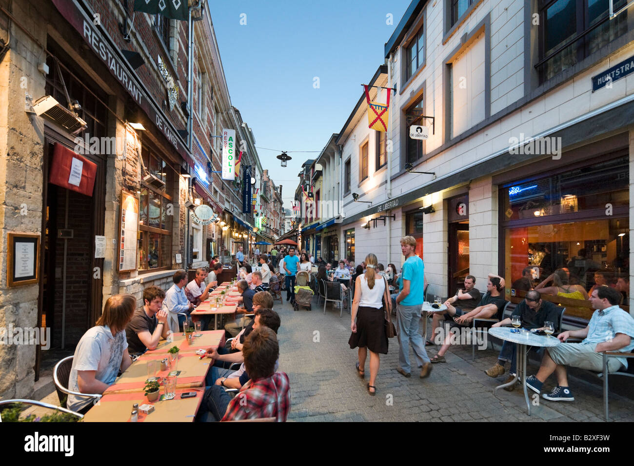 Restaurantes en la acera en la angosta calle peatonal de Muntstraat, Leuven, Bélgica Foto de stock