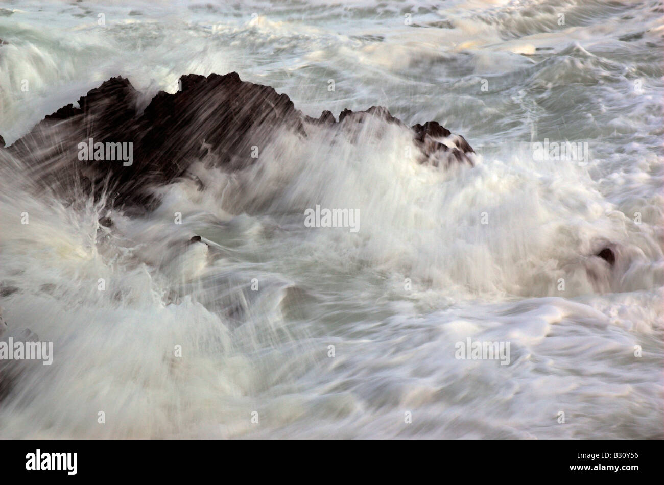 Olas rompiendo sobre las rocas, en la península de Gower Foto de stock