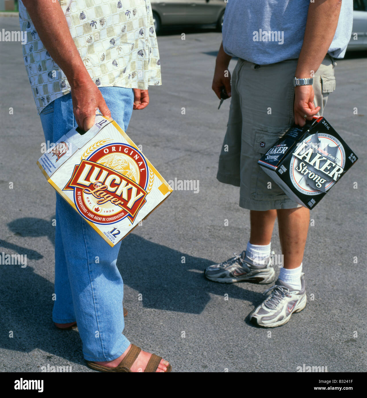 Los hombres fuera "El Almacén" de cerveza Holding la caja de Lucky Lager y Laker cerveza fuerte en Ontario Canadá KATHY DEWITT Foto de stock