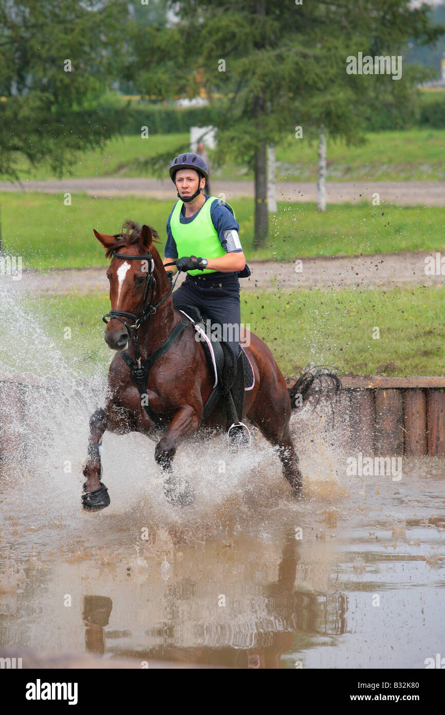 Joven monta un caballo yegua bahía cross country en competencia de eventos Foto de stock