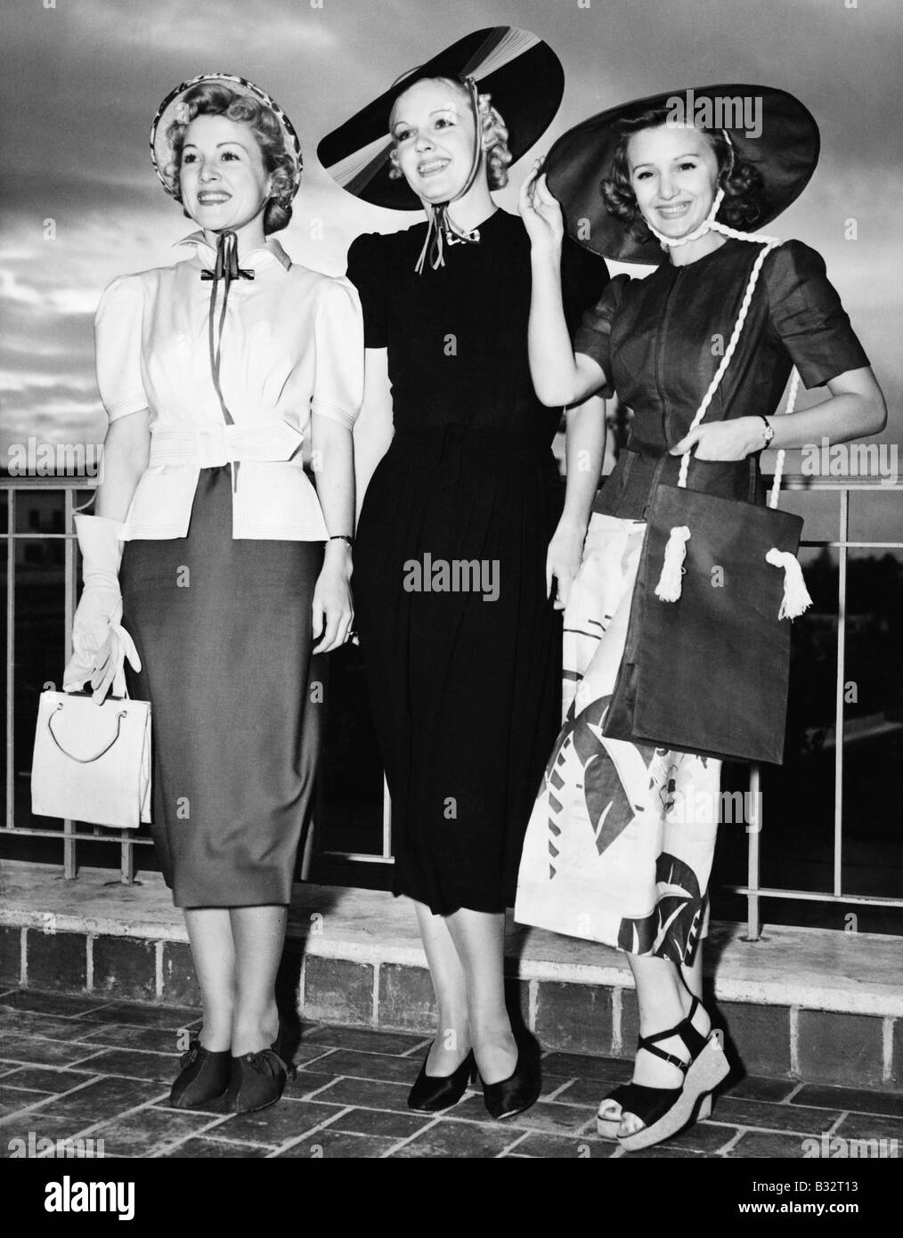Tres jóvenes mujeres de pie al lado de la otra y sonriente Foto de stock