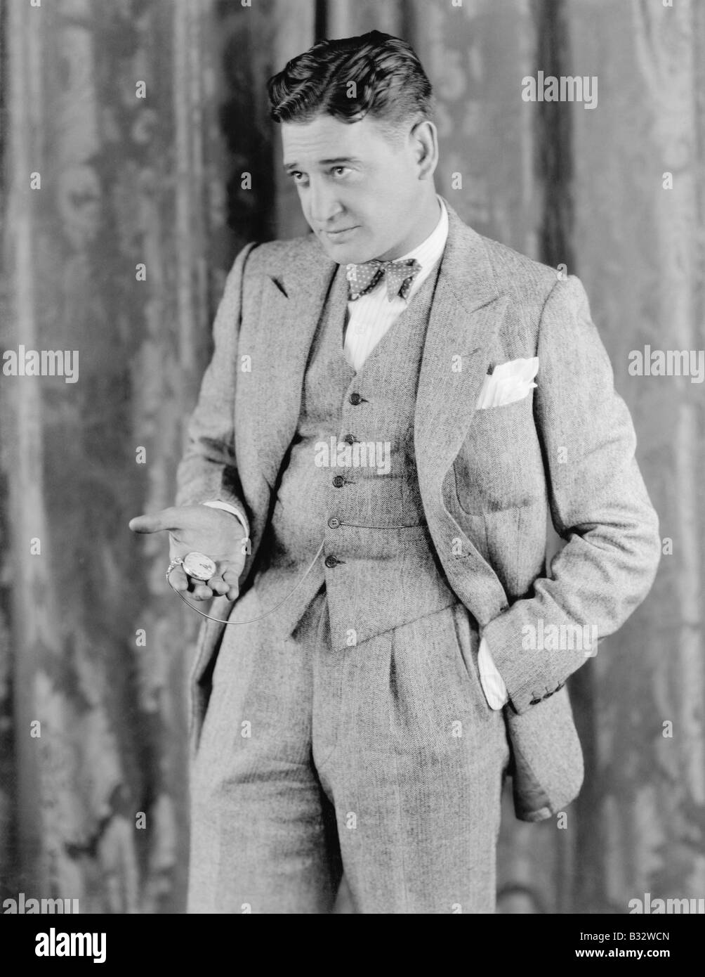 Hombre en un traje de celebración de su reloj de bolsillo Fotografía de  stock - Alamy