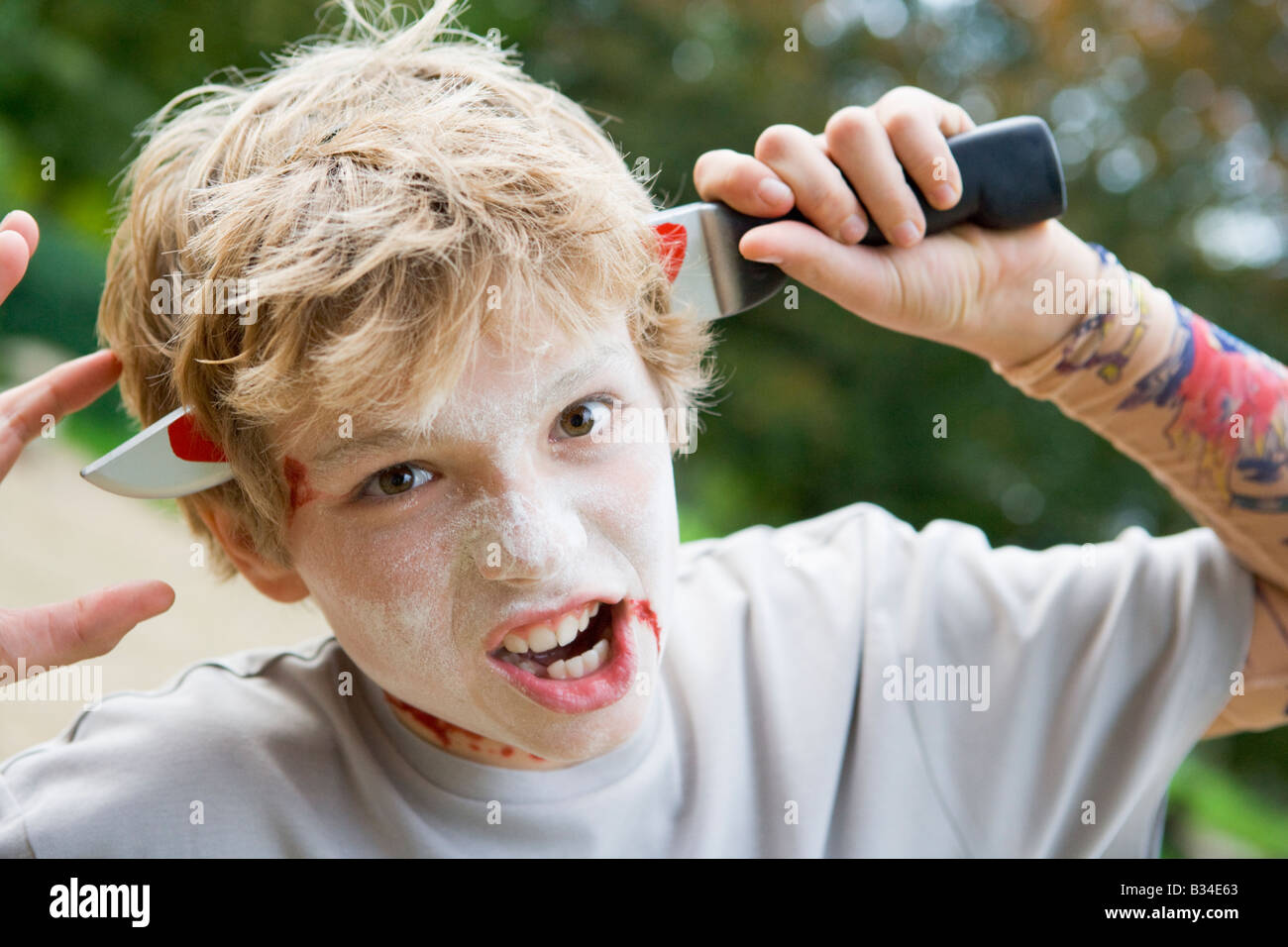 Joven con maquillaje de Halloween y cuchillo de plástico a través de la  cabeza Fotografía de stock - Alamy