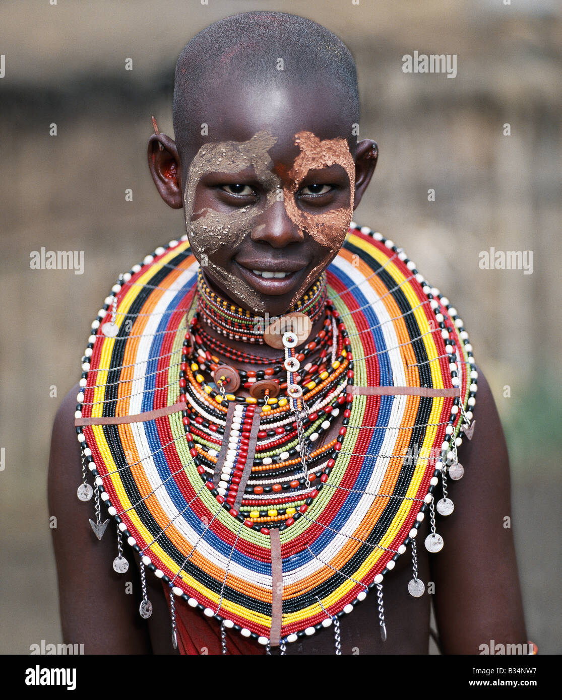 Kenya, Trans-Mara, Lolgorien. Un joven Masai niña usa pintura facial y numerosos ornamentos biselado en preparación para un baile con los guerreros. Foto de stock