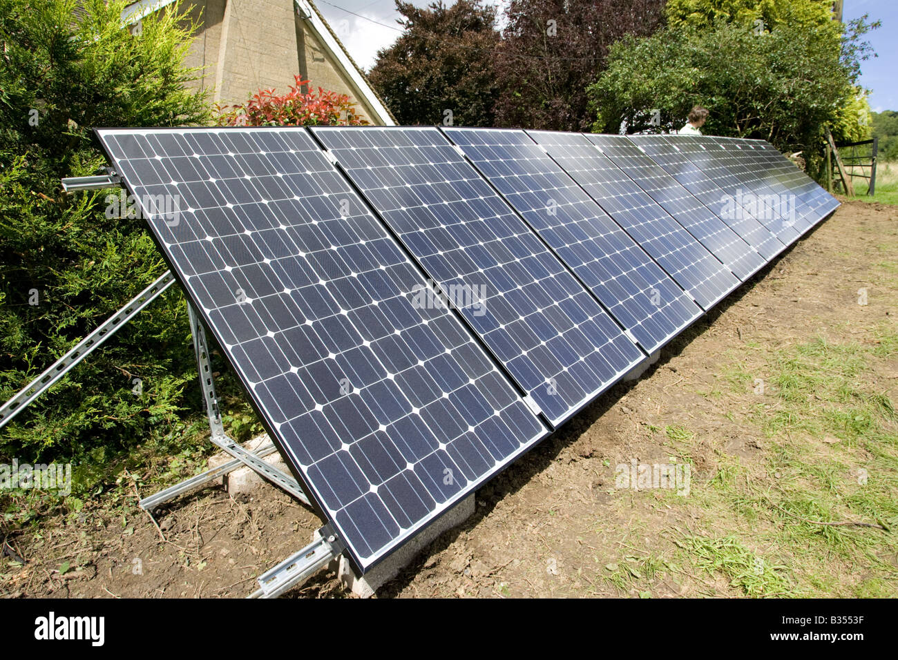 Matriz de 12 híbridos solares PV 210w paneles sobre un bastidor galvanizado en campo Cotswolds UK Foto de stock