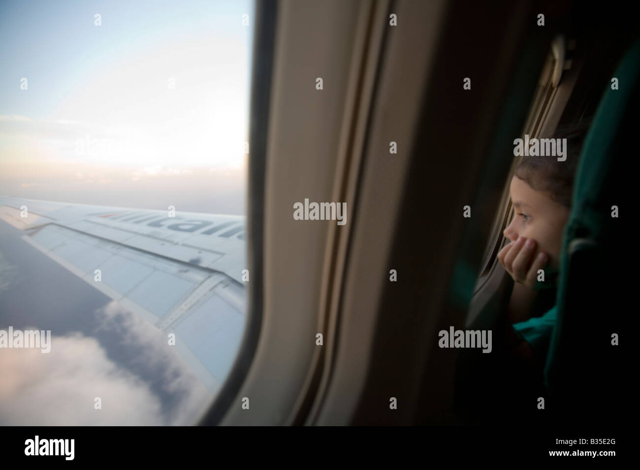 Niña mirando fuera de la ventana de un vuelo de Airbus Foto de stock