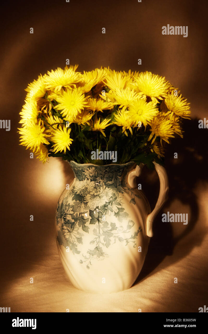 Una antigua jarra de flores de crisantemo amarillo. Foto de stock