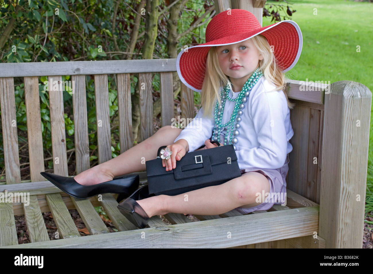 Niña de 3 años de edad en el jardín vestirse en crecido ropa Foto de stock