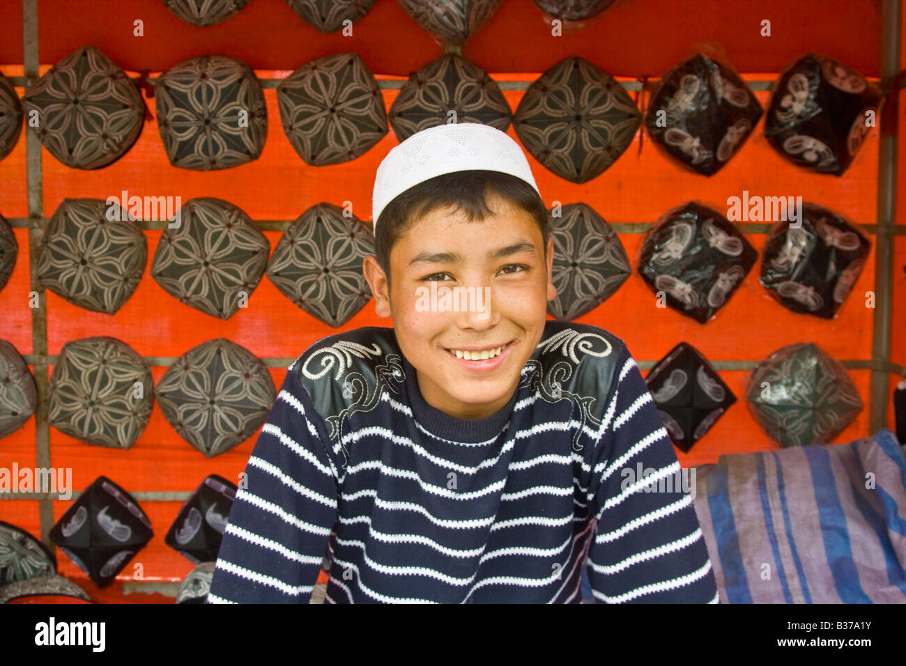 Sombreros a la venta Chico uigur el mercado dominical de Hotan, en la provincia de Xinjiang China Foto de stock