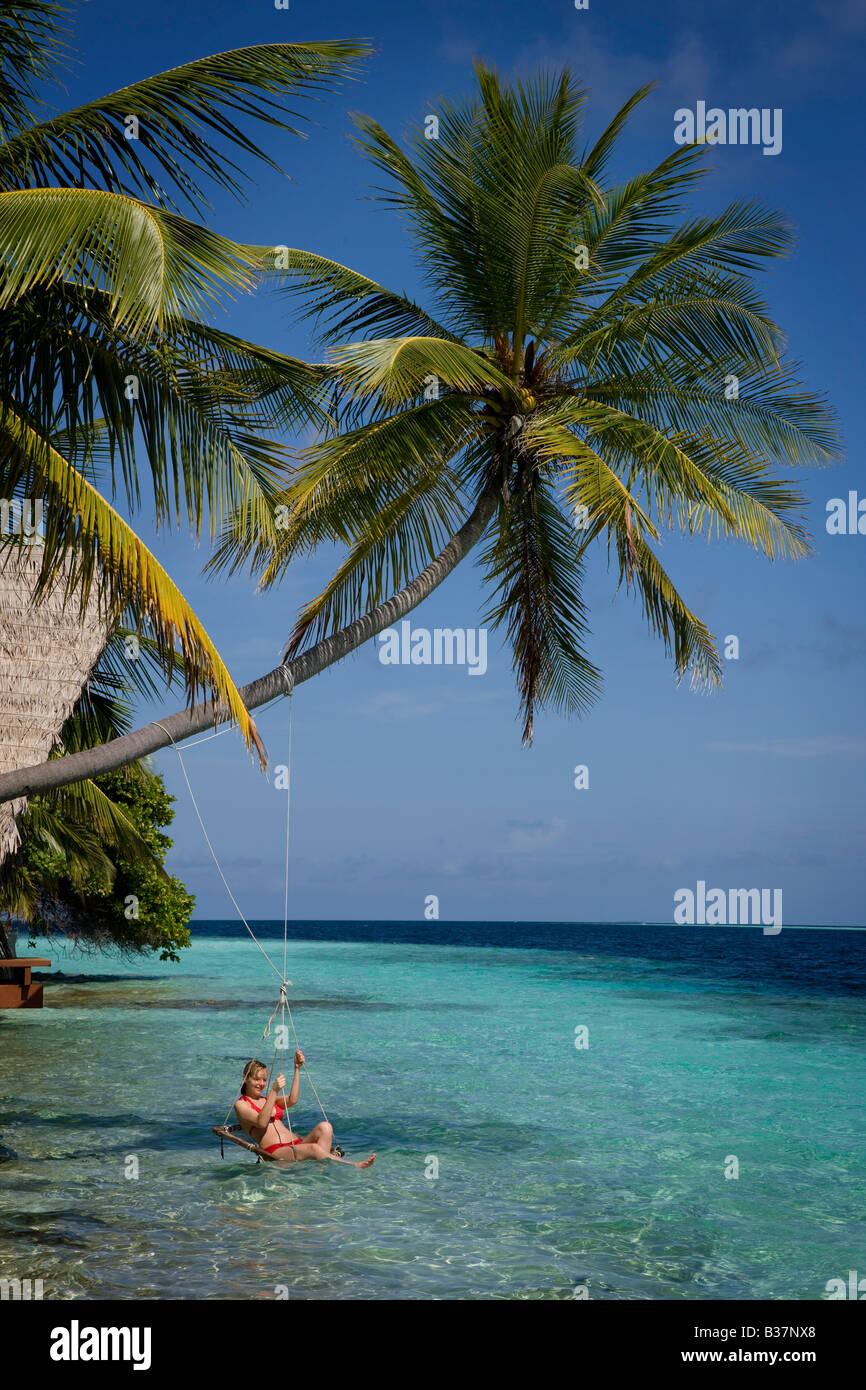 Chica balanceándose en el columpio en el Atolón Ari sur en Maldivas cerca de India Foto de stock