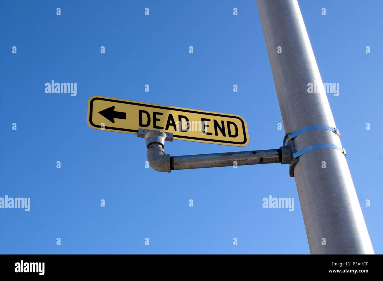 Amarillo Dead End Street signo en poste de luz larga con el azul claro del cielo Foto de stock