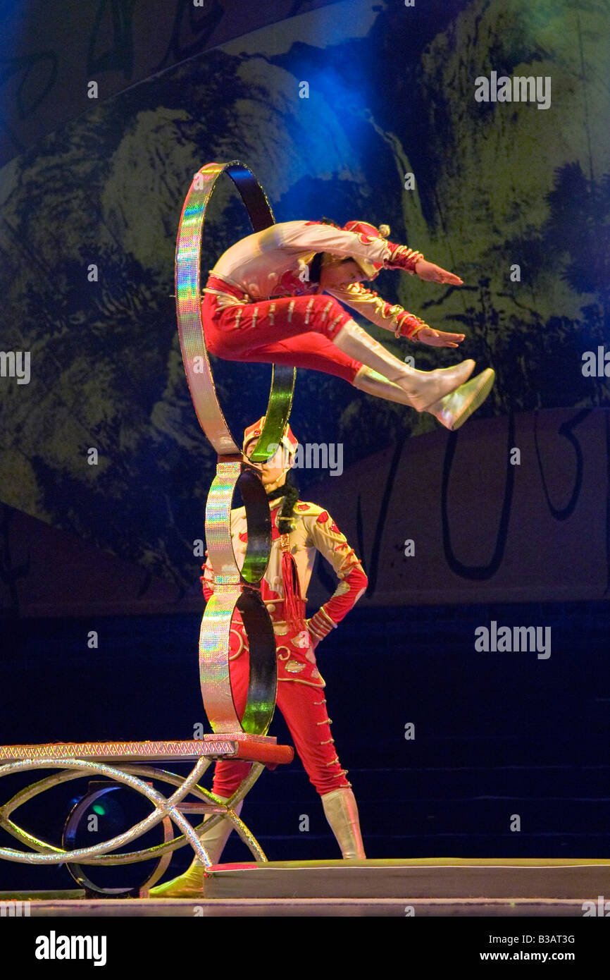 Acrobat en medio del aire pasa a través del aro en el espectáculo acrobático de Beijing China JMH3207 Foto de stock