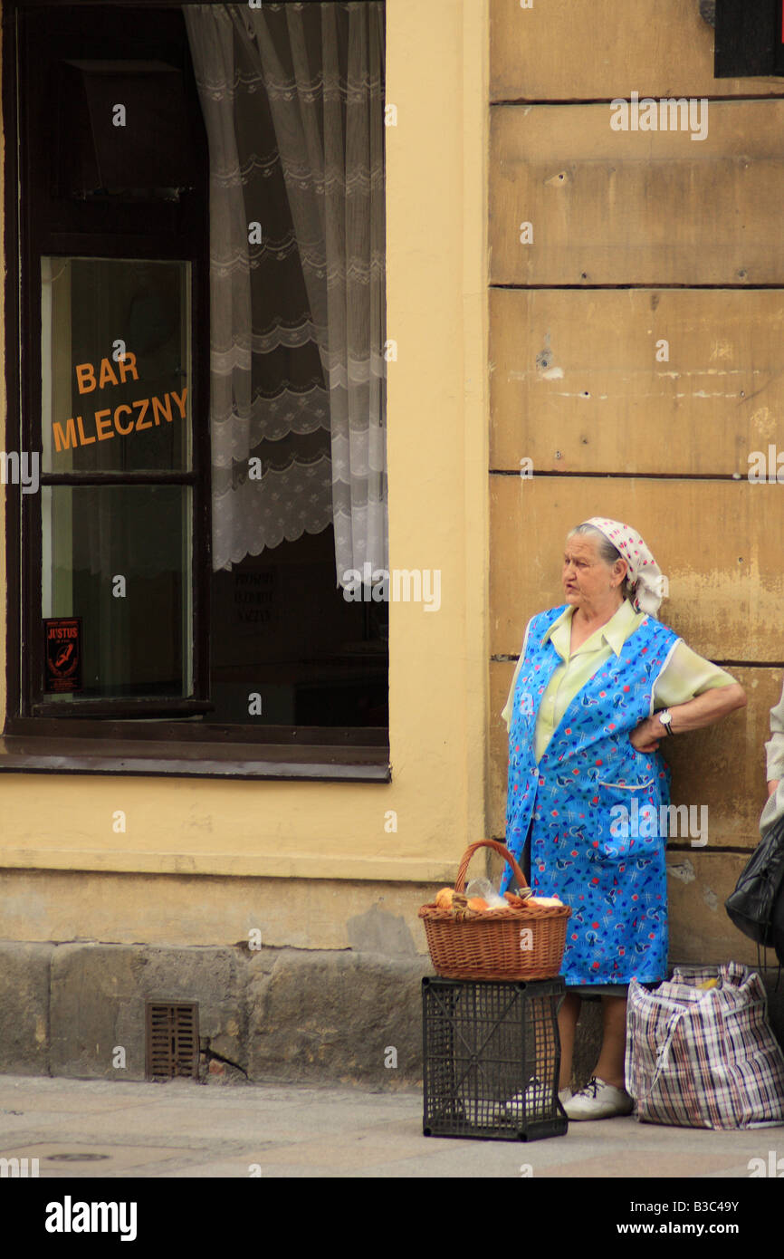 Anciana que vende pan en la calle Pod temida milk bar (bar mleczny) en Cracovia, Polonia Foto de stock