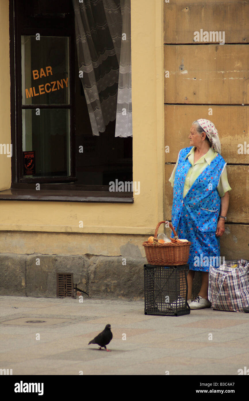 Anciana vendiendo pan en la calle Pod temida milk bar en ul. Grodska en Cracovia, Polonia Foto de stock