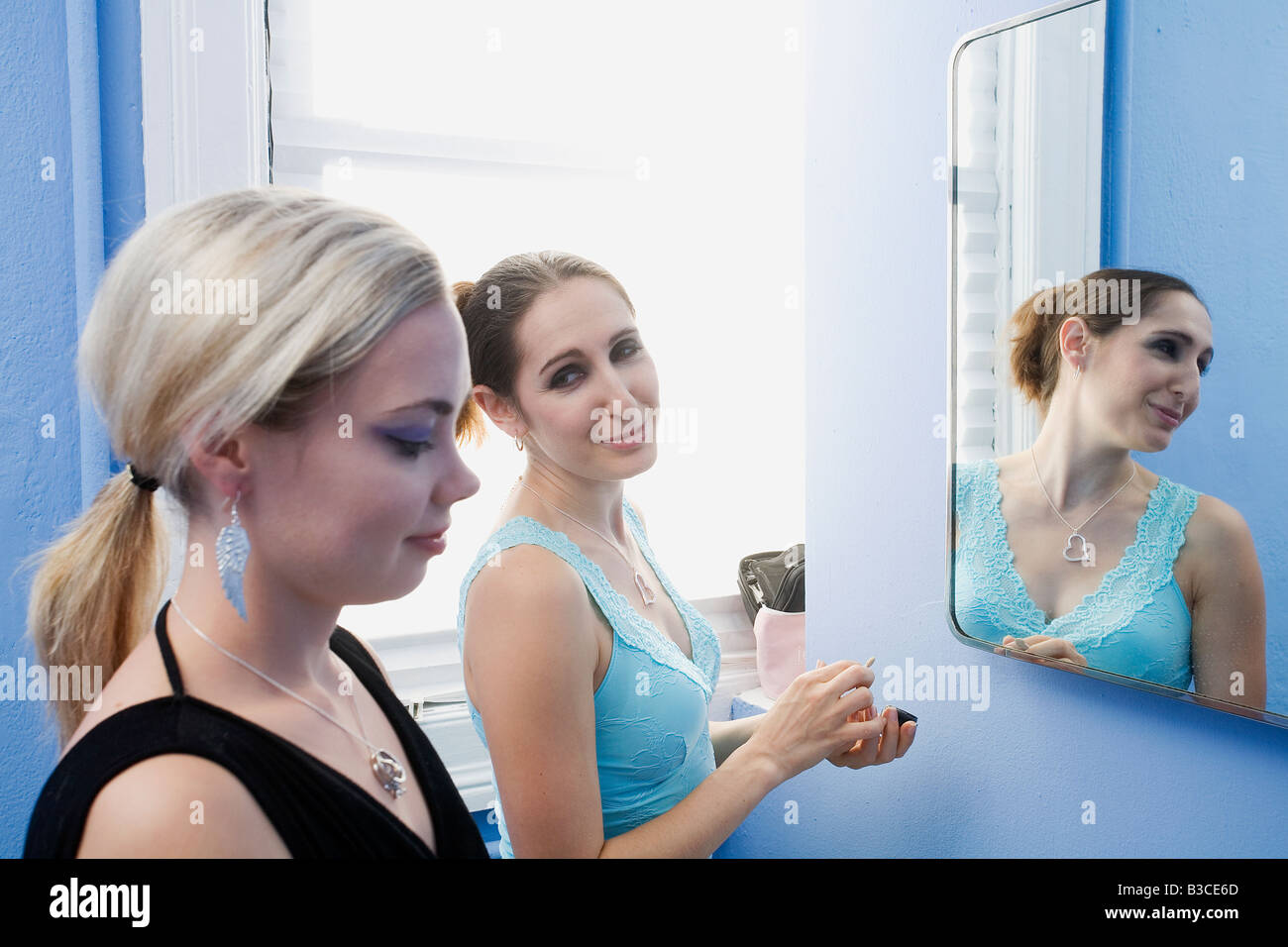 Las mujeres jóvenes de pie delante del espejo Foto de stock