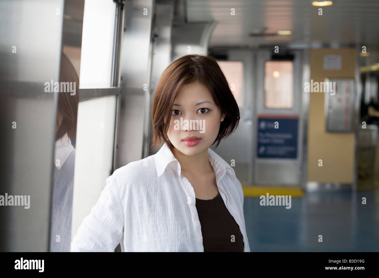 Mujer joven de pie junto a la ventana, Retrato Foto de stock