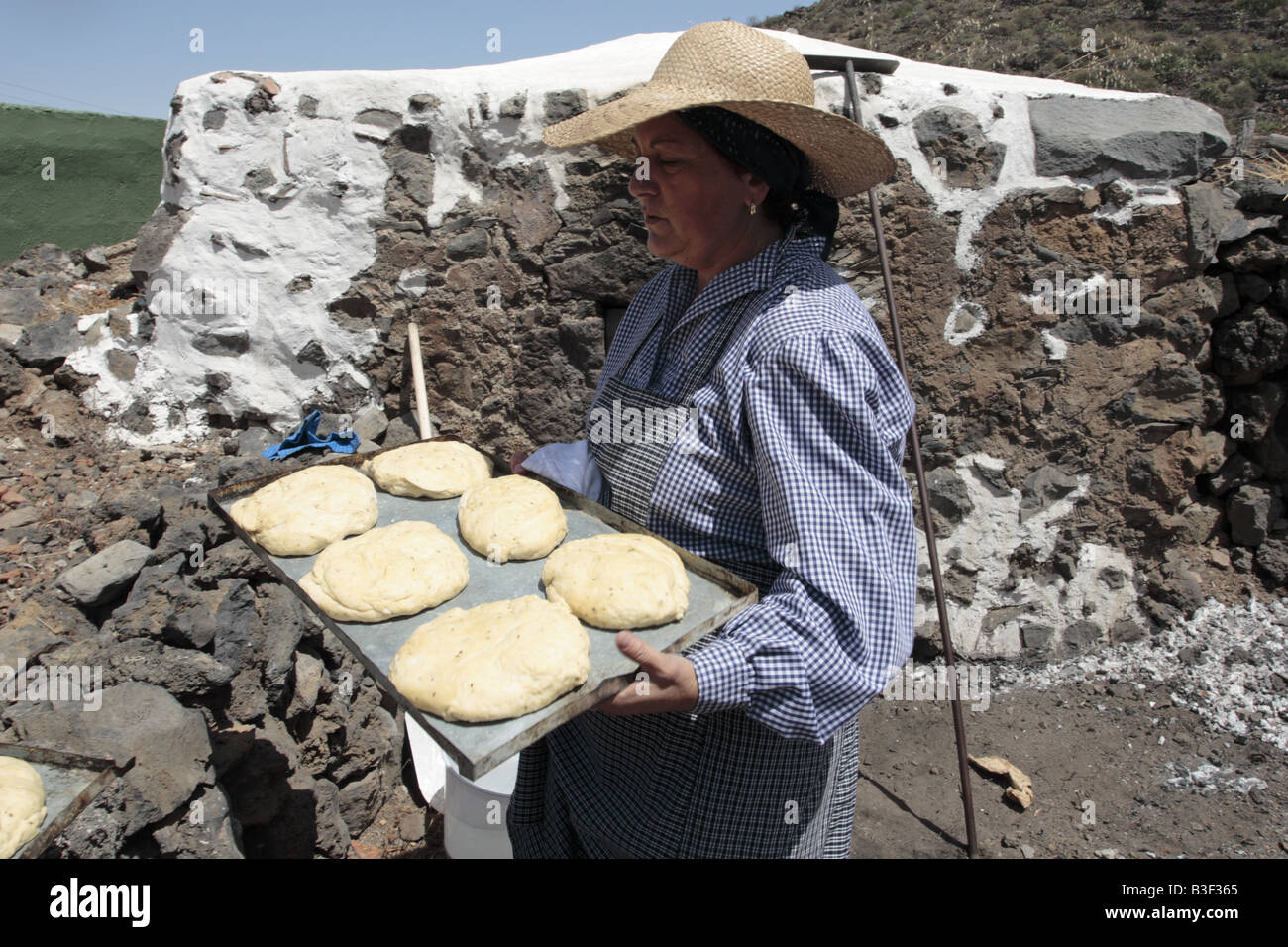 Una mujer sostiene una bandeja de pasta listo para ser colocado en un horno  de pan comunal para hornear de Chirche Tenerife Islas Canarias Fotografía  de stock - Alamy