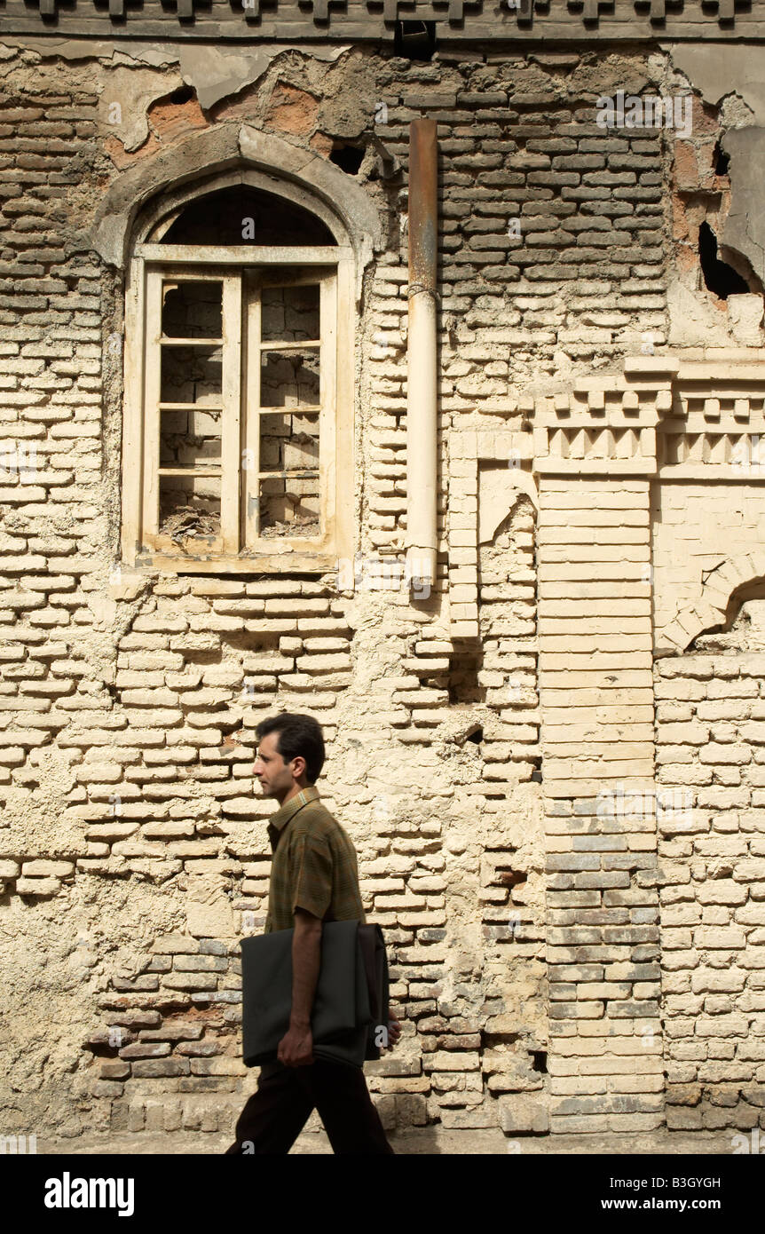 Un hombre que camina delante de una vieja casa abandonada cerca del Gran Bazar de Teherán Foto de stock