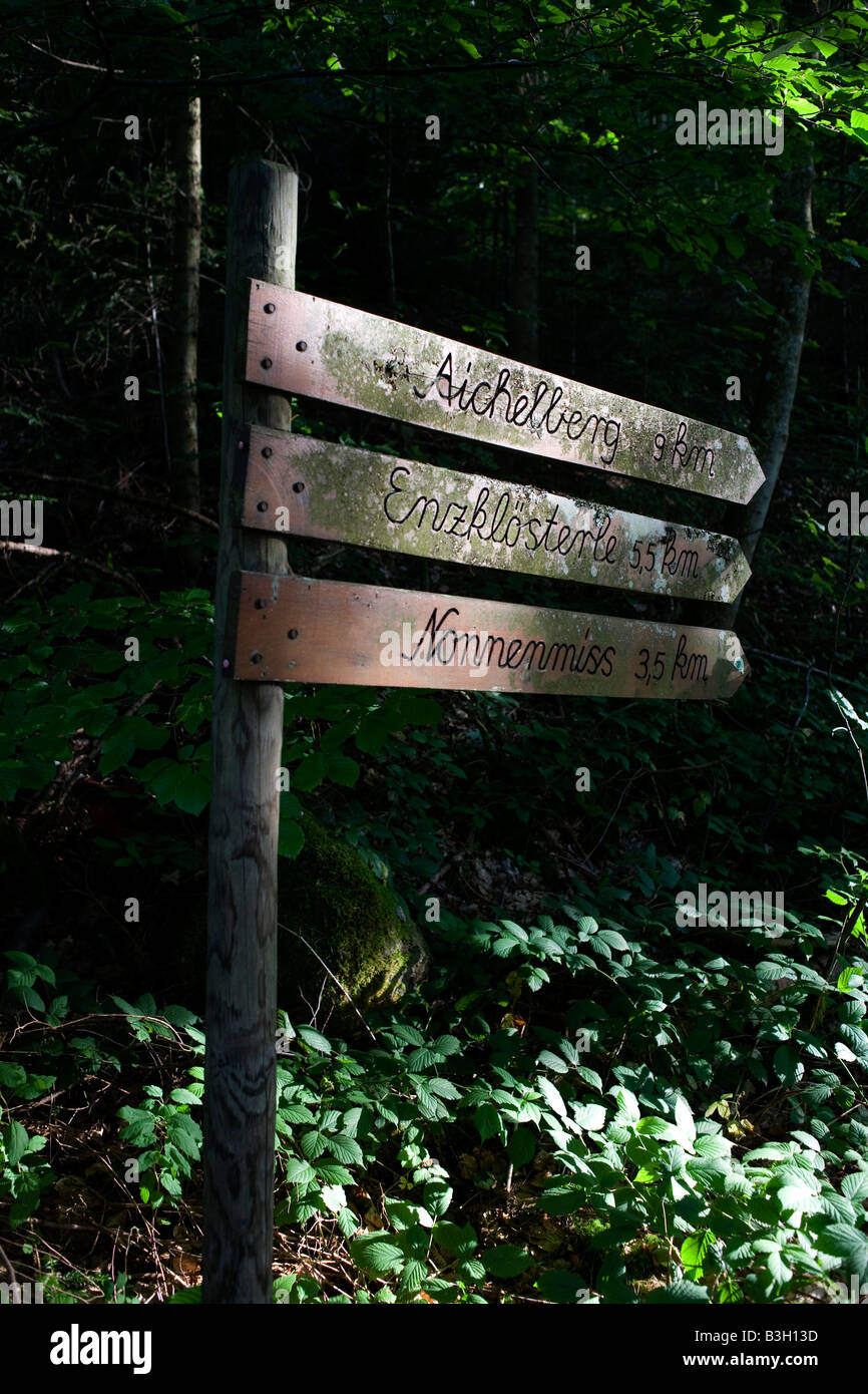 Ruta a pie signo marca distancia en km a través del bosque oscuro en la región de la Selva Negra alemana cerca de la aldea de Kälbermühle Foto de stock