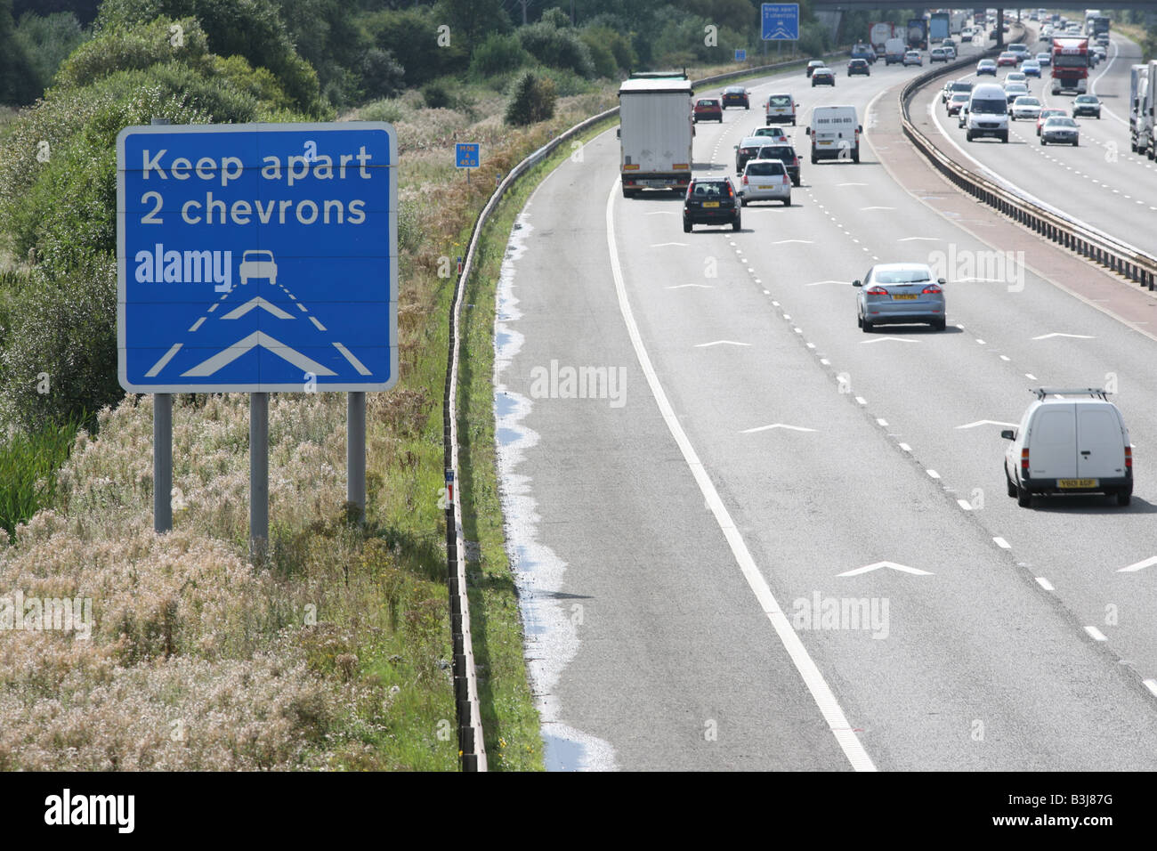 Mantener separados a 2 chevrons autopista carretera firmar y marcas, M56 en el noroeste de Inglaterra Foto de stock