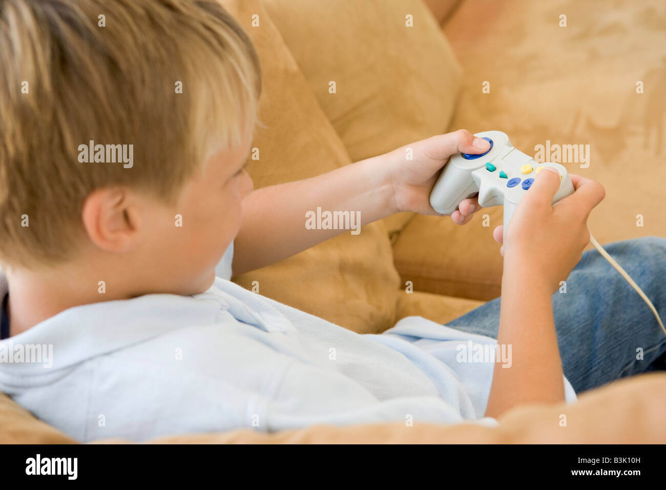 Joven en la sala de estar con video game controller Foto de stock