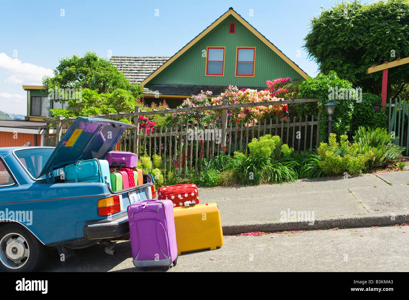 Del maletero del coche cargado con maletas de colores en la parte frontal  de la casa Fotografía de stock - Alamy