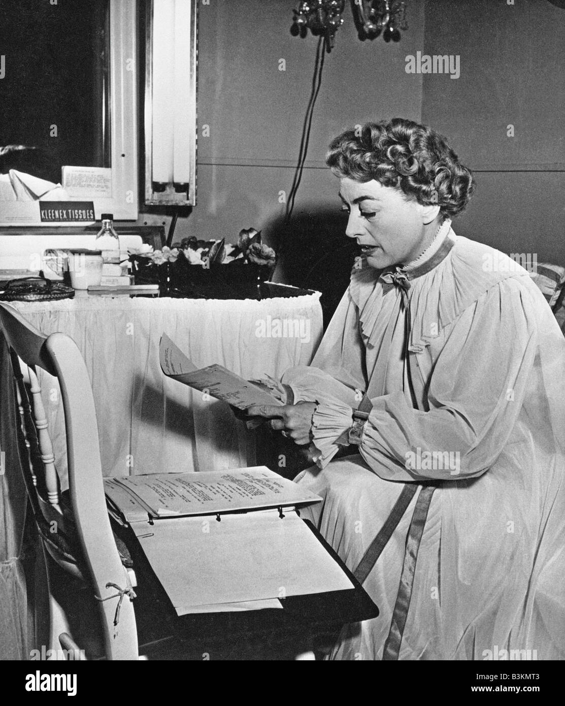JOAN Crawford, actriz de cine estadounidense leer el guión de su película miedo repentino en 1952 Foto de stock