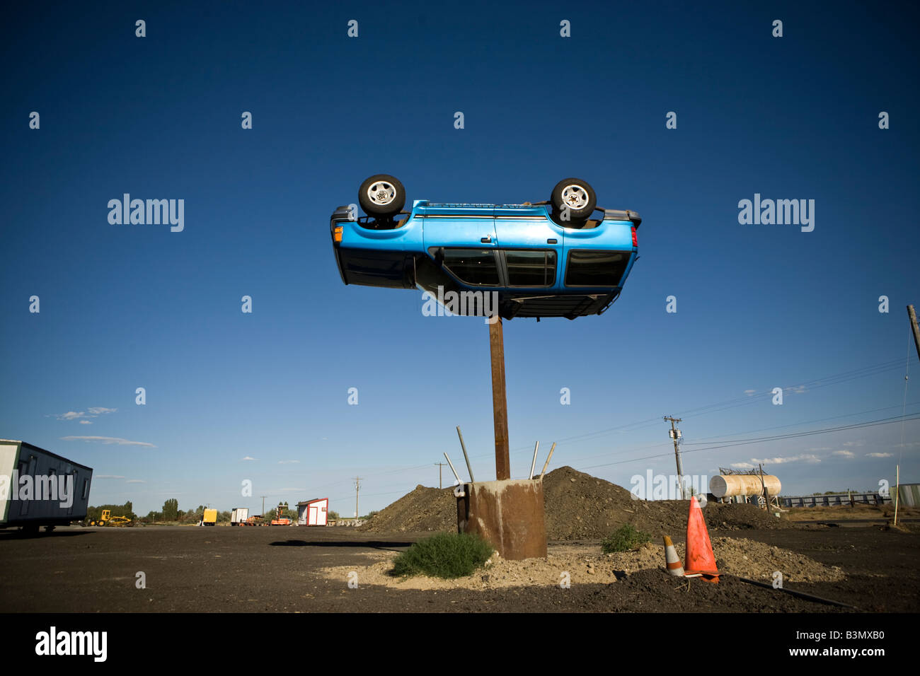 Un Ford Explorer SUV al revés se asienta sobre una columna de metal de 15 pies de alto. Foto de stock