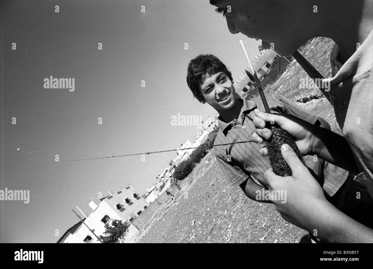 Dos muchachos palestinos volar una cometa y jugando en la ciudad Cisjordania de quarqulia Foto de stock