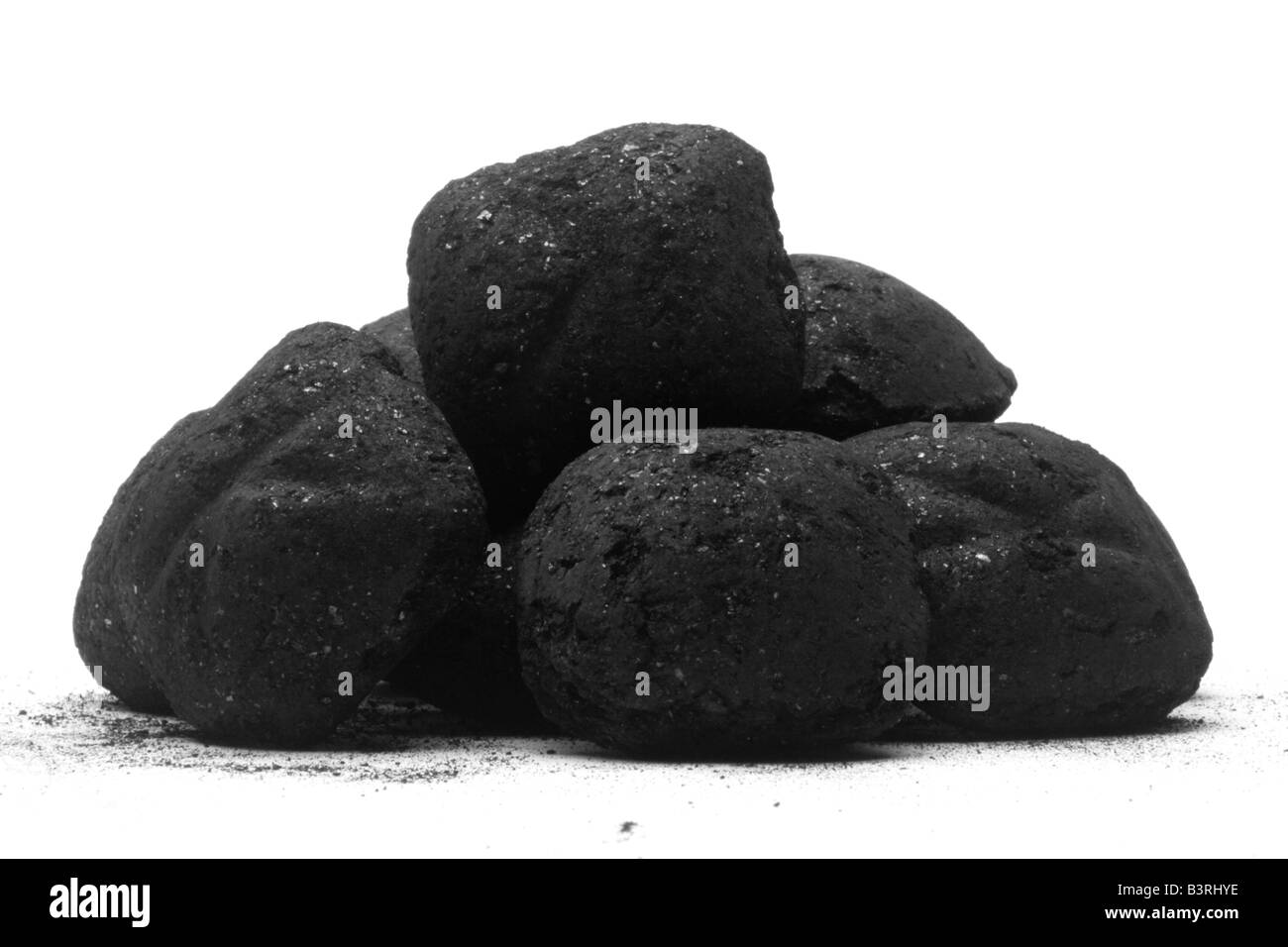 Montón de carbón briquets aislado contra un blanco Foto de stock