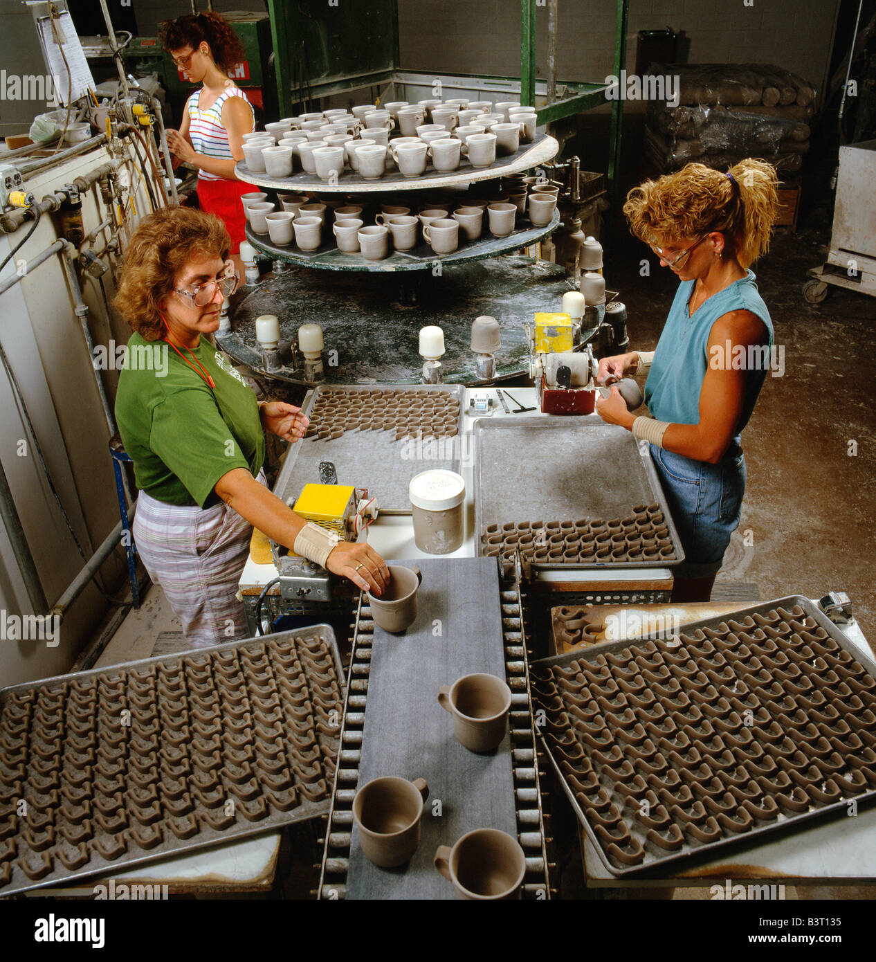 Las trabajadoras pegamento asas para vasos. La compañía PFALTZGRAFF, alfarería Company, EE.UU. Foto de stock