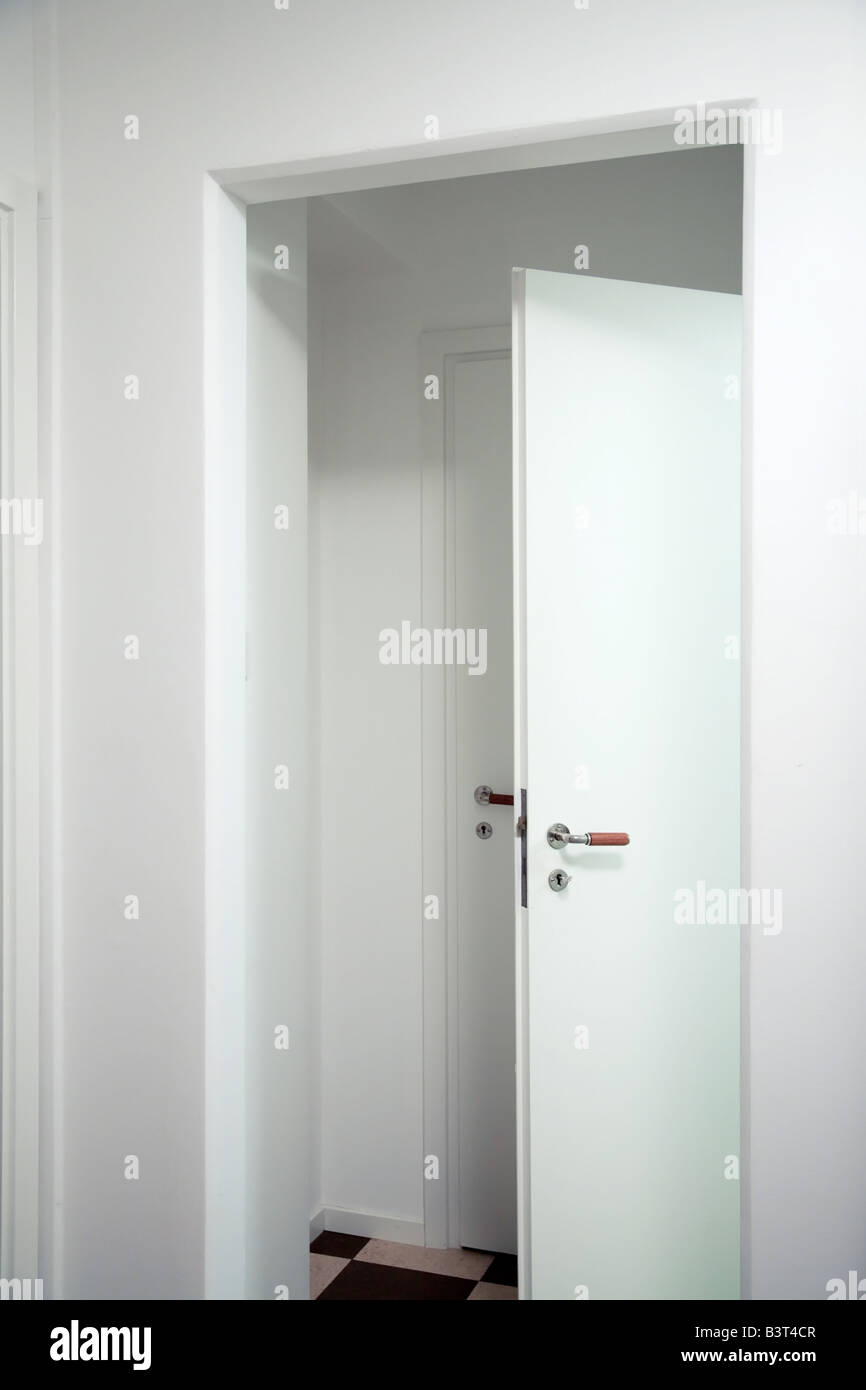 Un medio abierto puerta blanca delante de una puerta blanca cerrada  Fotografía de stock - Alamy