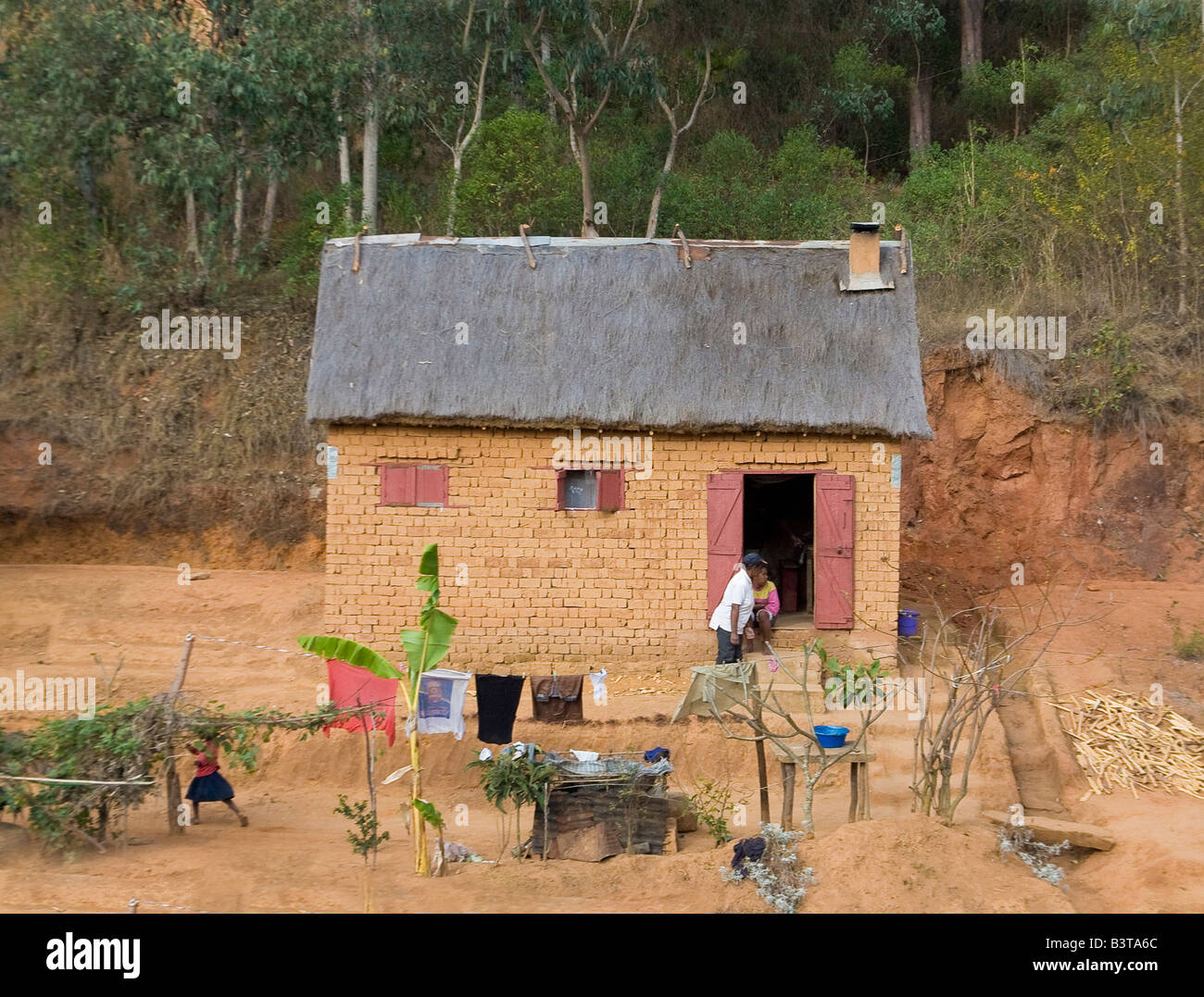 África, el Océano Índico, Madagascar. Gente fuera de techo de paja, la casa  de ladrillo Fotografía de stock - Alamy