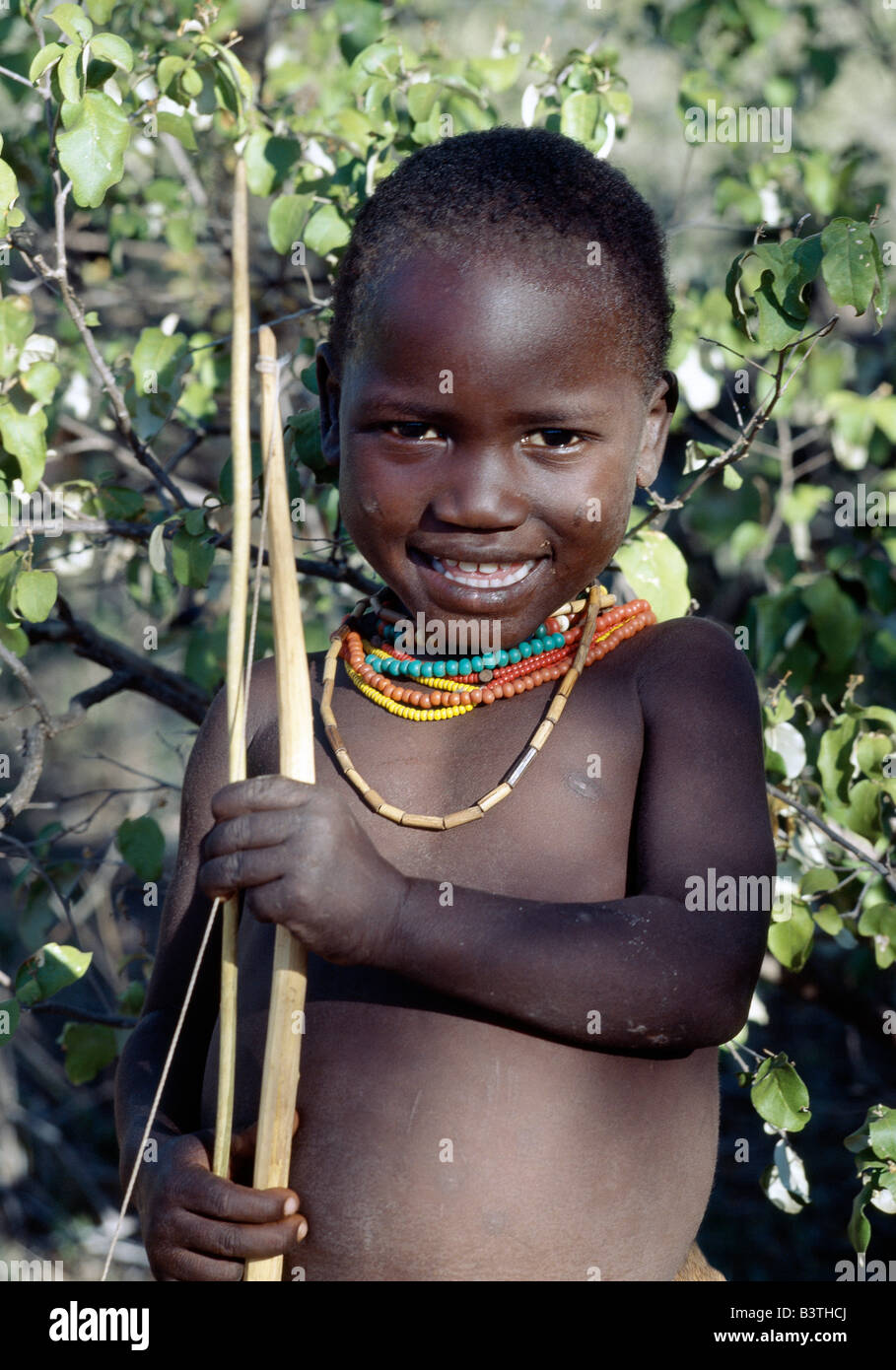 Tanzania, Arusha, lago Eyasi. Un muchacho Hadza llevando un arco y una flecha. Los Hadzabe son mil-fuerte comunidad de cazadores-recolectores que vivían en la cuenca del lago Eyasi durante siglos. Ellos son uno de sólo cuatro o cinco sociedades en el mundo que todavía viven principalmente de recursos silvestres. Foto de stock