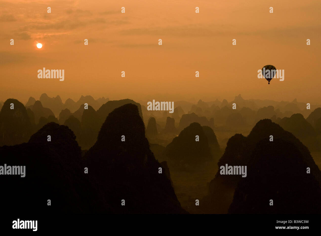 Globo y colinas de piedra caliza al amanecer en Yangshuo, Guangxi Foto de stock