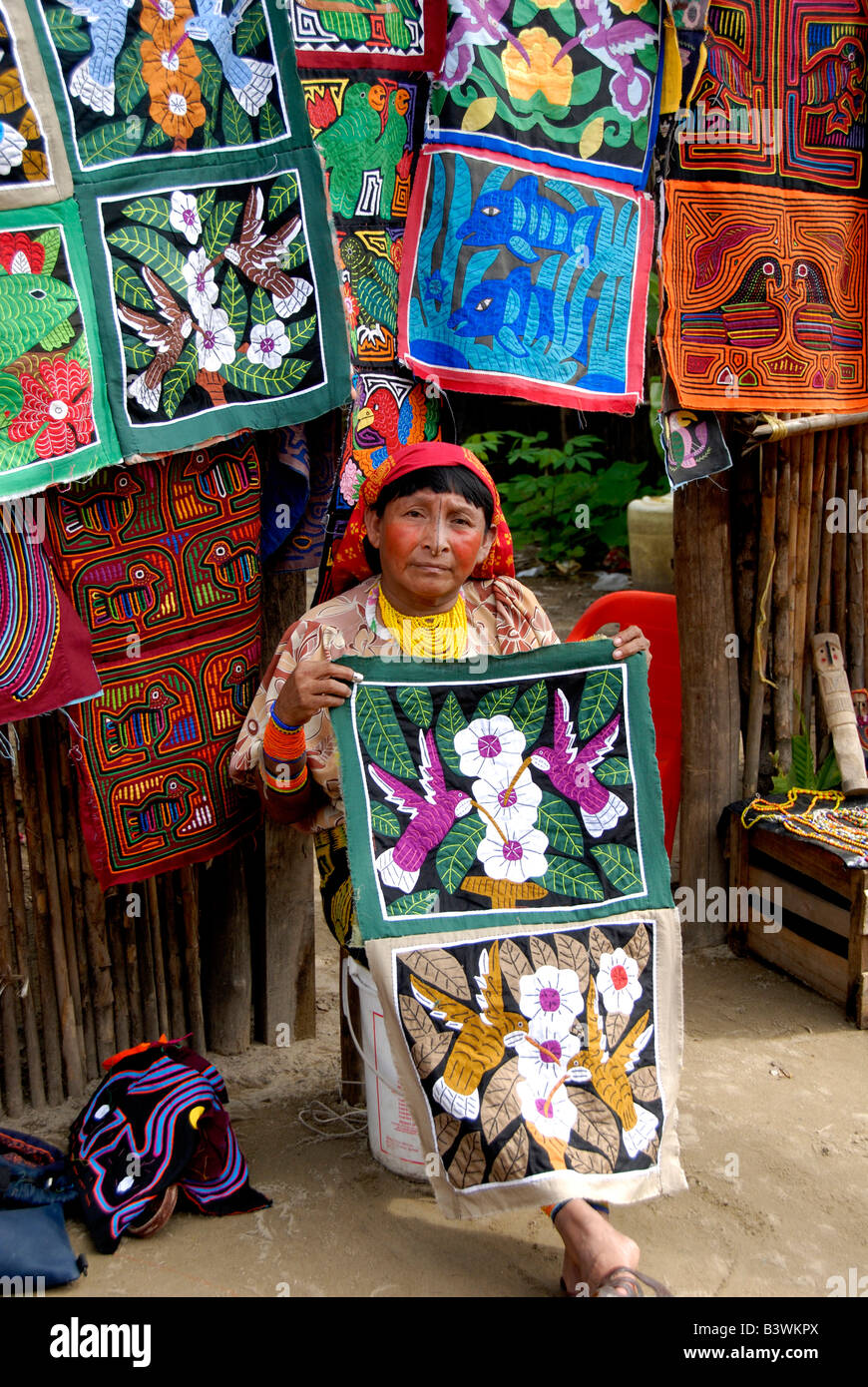 América Central, Panamá, las Islas de San Blas. Mujer indígena Kuna en traje tradicional delante de coloridas molas cosida a mano. Foto de stock