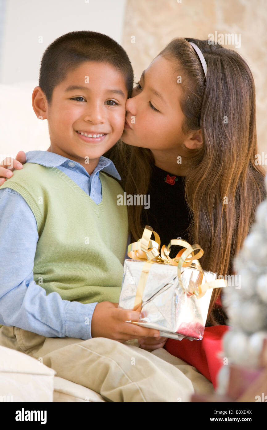 Hermana Dando A Su Hermano Un Regalo De Navidad Y Le Beso En La Mejilla Fotografía De Stock Alamy 2745
