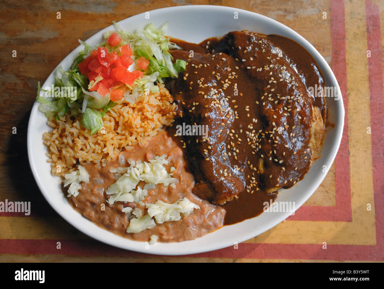 Enchiladas de pollo con mole poblano salsa y el arroz y los frijoles