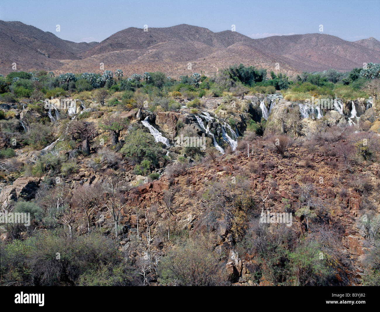 Namibia, Kaokoland, Epupa. La atractiva Epupa Falls en el accidentado noroeste de Namibia son una serie de canales paralelos, donde el río Kunene desciende a 60 metros en un kilómetro y medio. En esta remota región, el río forma la frontera entre Angola y Namibia. "Epupa' en el idioma Herero local significa 'Falling Waters'. Foto de stock