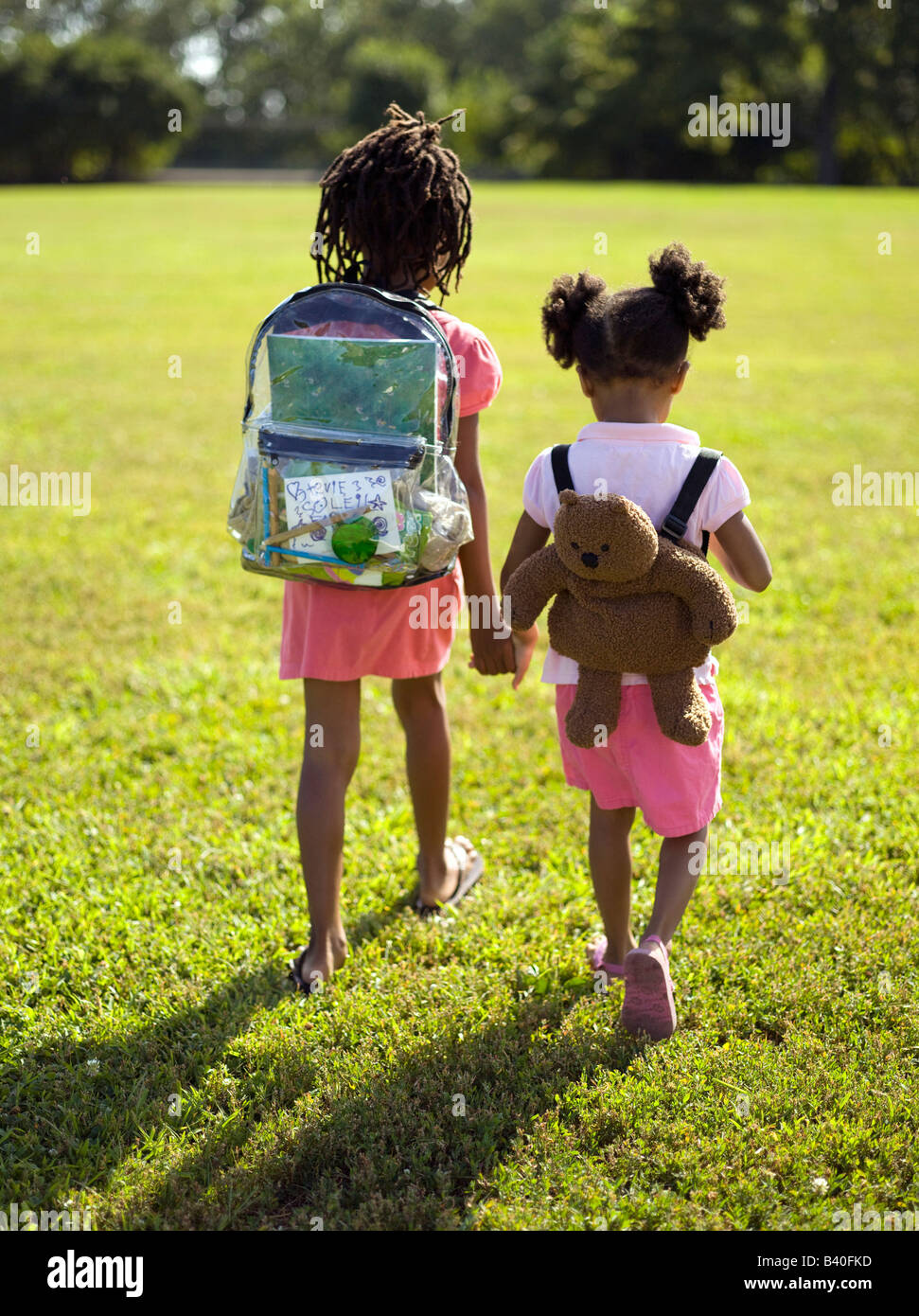 La pequeña niña fuera andando con un oso de peluche en la mochila  Fotografía de stock - Alamy