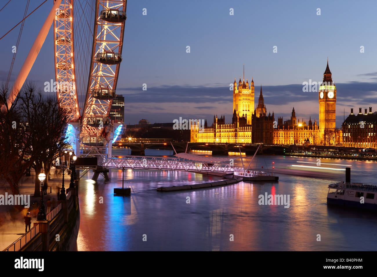 El terraplén (orilla sur) con el Ojo de Londres, el río Támesis y el Palacio de Westminster al anochecer, Londres, Inglaterra, Reino Unido. Foto de stock