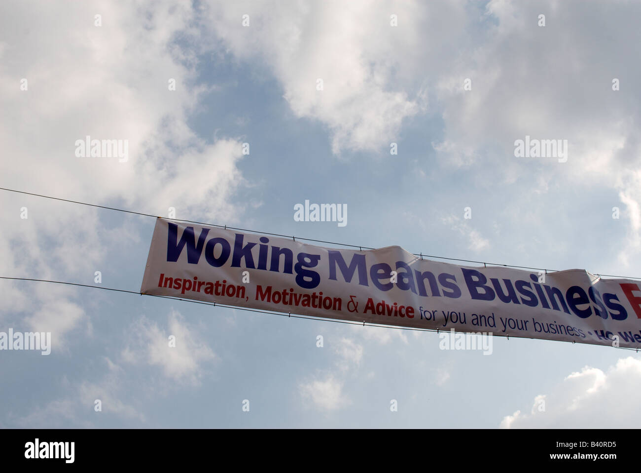 De Woking (Surrey, Inglaterra en el REINO UNIDO significa negocio banner contra el cielo Foto de stock