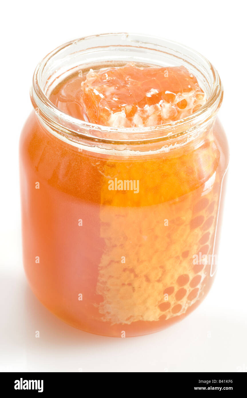 Panal con abejas y frasco de miel en mesa Fotografía de stock - Alamy